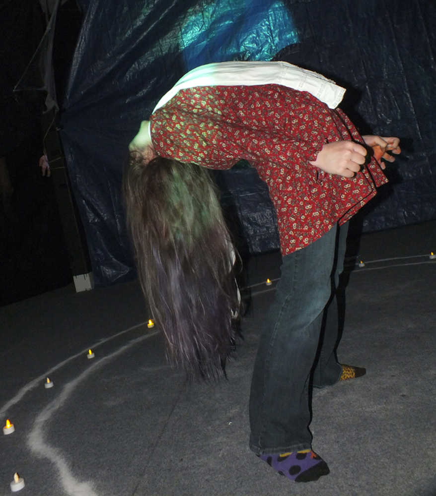Ben Boettger/Peninsula Clarion Freshman Emilie Fuhrman performs contortions as a demon-possessed player in Soldotna High School Drama Troupe's haunted house fundraiser on Tuesday, October 28, 2014, at the Peninsula Center Mall.