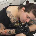 Ben Boettger/Peninsula Clarion Joe Hayes inks a tattoo on Ami Stowell's leg  at Ink Works Tattoo Studio in Kenai on Nov. 8.