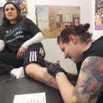 Ben Boettger/Peninsula Clarion Joe Hayes inks a tattoo on customer Ami Stowell's leg at Ink Works Tattoo Studio in Kenai on Nov. 8.