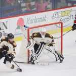 Photo by Kelly Sullivan/ Peninsula Clarion Kenai Brown Bears' Nick Klishko helps goalie Alec Derks depend the goal against a shot from the Minnesota Magicians, Friday, November 14, 2014 at the Soldotna Regional Sportd Complex in Soldotna, Alaska.