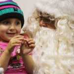 Photo by Kelly Sullivan/ Peninsula Clarion Harper Samskar sat on Santa Claus's lap for the first time at Christmas Comes to Kenai November 28, 2014, in at the Kenai Chamber of Commerce and Visitor Center in Kenai, Alaska. Harper Samskar went with her parents, Ashly Samskar and Char Samskar, and told Santa Claus she wanted candy for christmas, as she held a large candy cane in her hand.