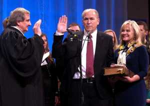 Bill Walker, center, is sworn in as Alaska's new governor as Alaska Supreme Court Justice Daniel Winfree, left, administers the oath of office on Monday, Dec. 1, 2014, in Juneau, Alaska. Also pictured at right is Walker's wife, Donna. The Bible on which Walker took his oath has been in his family since the 1800s, according to his spokeswoman. (AP Photo/Becky Bohrer)