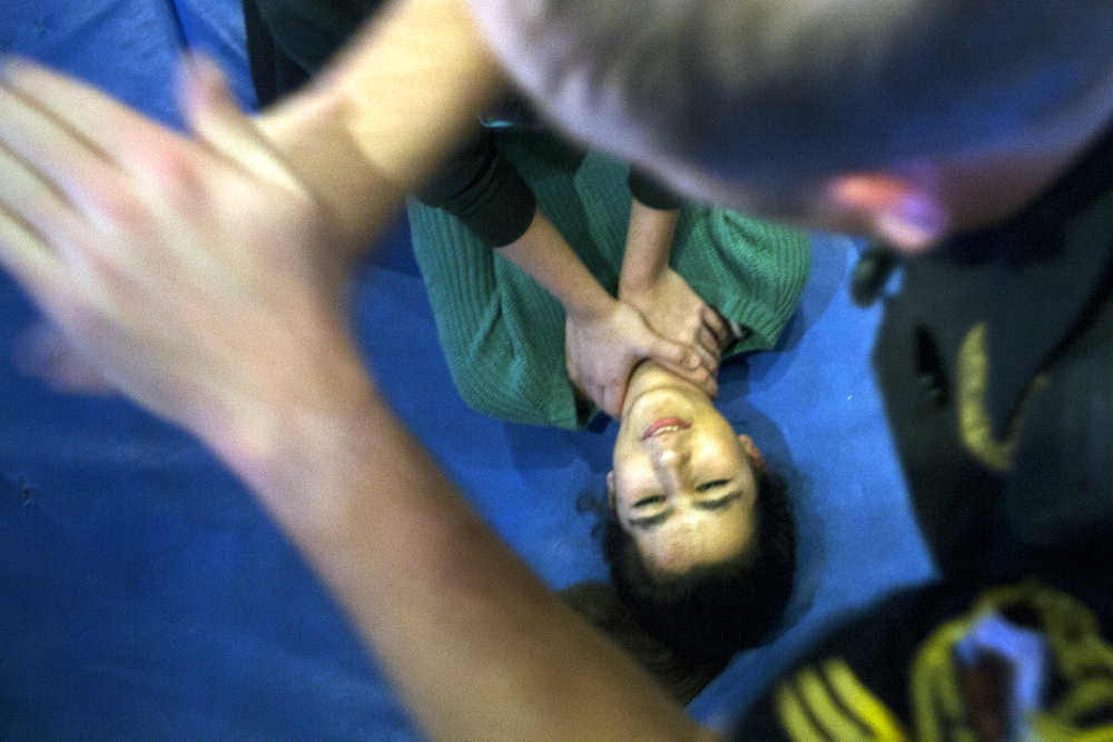 Photo by Rashah McChesney/Peninsula Clarion  Kenai Police Officer Jay Sjogren demonstrates a manuever to Sara Benrhouma, of Kasilof, during a Teens on Target self-defense class on Thursday Dec. 11, 2014 in Kenai, Alaska.