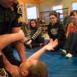 Photo by Rashah McChesney/Peninsula Clarion  Kenai police officers Jay Sjogren and Alex Prins demonstrate a manuever during a Teens on Target self defense class on Thursday Dec. 11, 2014 in Kenai, Alaska.