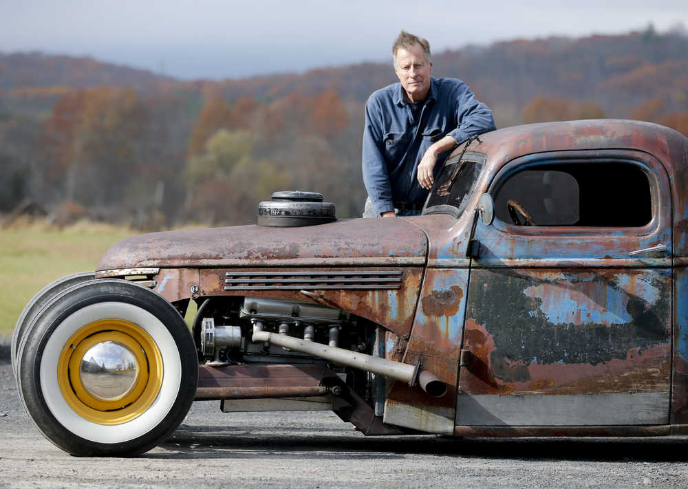 Peter Duvaloois poses with his Rat Rod on Tuesday, Nov. 11, 2014, in Saugerties, N.Y. The fast machines are pieced together from vintage parts and scrapyard finds. They are rumblier, rustier and turn more heads on the highway. (AP Photo/Mike Groll)