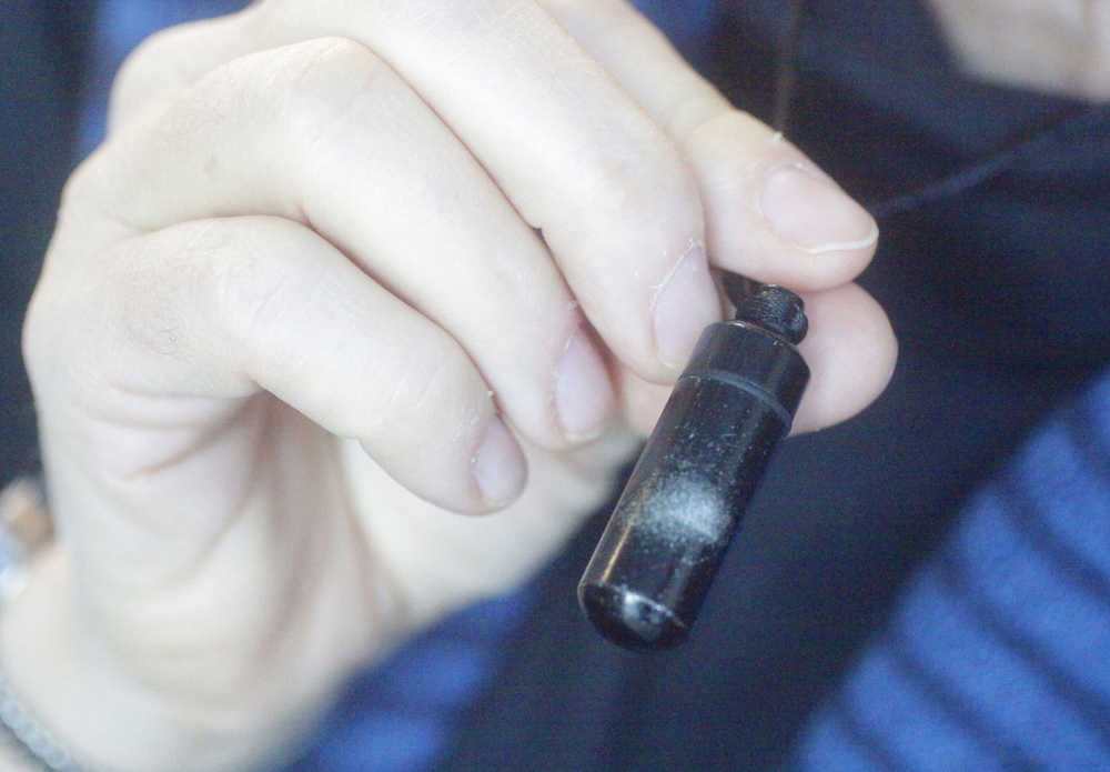 Photo by Kelly Sullivan/ Peninsula Clarion Compassionate Friends of the Kenai Peninsula steering committee member Leslie Boyd wears a vial of her son, Seth Boyd's ashes around her neck Saturday, Dec. 20, 2014 at the Joyce K. Carver Soldotna Public Library in Soldotna, Alaska. Seth Boyd was killed in a plane crash four years ago when he was 29 years old, Leslie Boyd said. "It was very sudden and very traumatic," Leslie Boyd said. "He was my only son, he was an adventurer, poker play, fly fishermen, a lover of beautiful women, many of whom are still my friends."