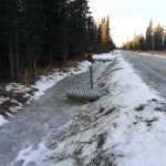 Photo by Dan Balmer/Peninsula Clarion A culvert underneath Buoy Avenue drains frozen retention water in a ditch dug out to keep surface water off the street. Photo taken December 19, 2014. Kenai Peninsula road service crews made ditch improvements to Buoy Avenue, which was built in 2003, this fall after the road saw significant flooding in 2013 because it was not built to borough road standards.