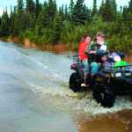 Clarion file photo Paul Vass and Julie Wendt drive down Bore Tide Drive during an October 2013 tour of the Kalifornsky area subdivision in which they live and raise livestock on a small farm. The couple suffered and estimated $30,000 in damage to their livestock and home during the month's long groundwater-flooding event that peaked from weekend rains
