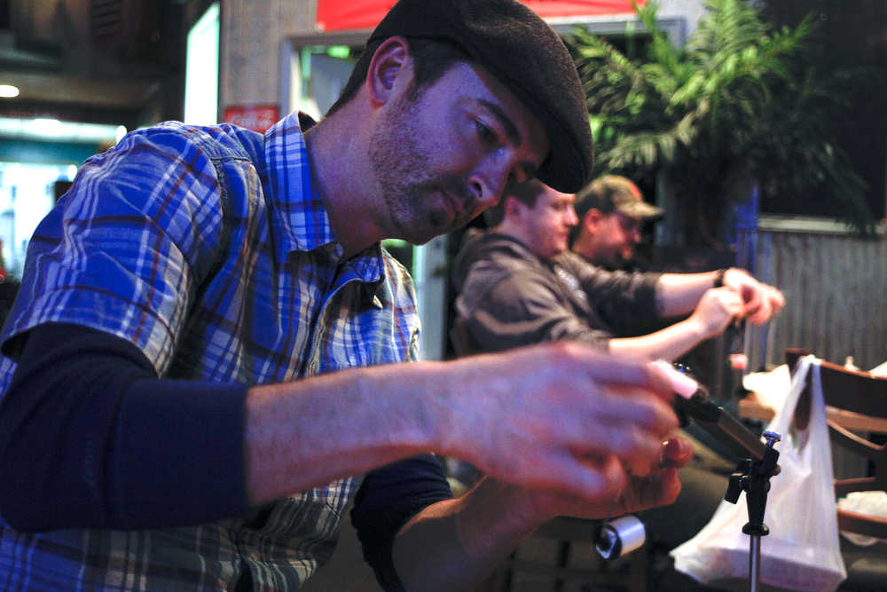Photo by Rashah McChesney/Peninsula Clarion  Toby Long works on a fly during a free class sponsored by the Kenai Peninsula Chapter of Trout Unlimited on Tuesday Jan. 6, 2014 at the MAin Street Tap & Grill in Kenai, Alaska.