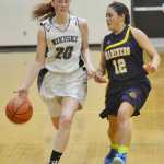 Photo by Rashah McChesney/Peninsula Clarion Nikiski Alison Litke looks for a path around Homer's Sofia Clark during their game on Saturday Jan. 10,  2015 at Nikiski Middle-High School in Nikiski, Alaska.