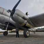 Photo by Rashah McChesney/Peninsula Clarion Spencer Wyman gives a fuel line to Zachary Sawyer as the two refill a WWII-era plane used by Everts Fuel Service on Tuesday Jan. 13, 2014 at the Kenai municipal airport in Kenai, Alaska.