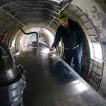 Photo by Rashah McChesney/Peninsula Clarion First Officer Zachary Sawyer walks through the belly of a WWII-era plane used by Everts Air Fuel Service after the plane landed at the Kenai airport to refill its tanks on Tuesday Jan. 13, 2014 in Kenai, Alaska.