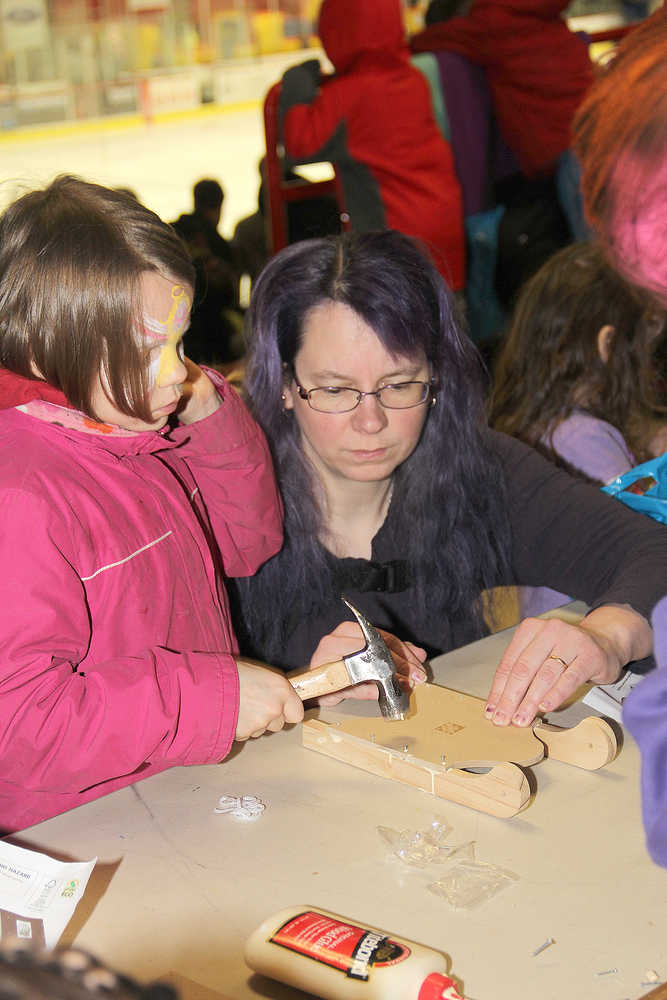 Home Depot volunteers help kids craft sleds & bird houses inside at Winter Games.
