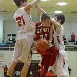 Kenai's Josh Jackman (22) splits Juneau-Douglas defenders Bryce Swofford (21) and Bruce Jones during the Kardinals' 63-50 loss to the Crimson Bears on Thursday in Juneau.