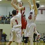 Kenai's Austin McKee floats a shot over Juneau-Douglas defenders Manase Maake (1) and Bruce Jones (43) during the Kardinals' 63-50 loss to the Crimson Bears on Thursday in Juneau.