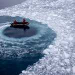 In this Jan. 22, 2015 photo, Chilean Navy officers push away ice by moving their boat in circles as they approach the Aquiles navy ship where they will pick up international scientists and take them to Chile's scientific Station Bernardo O'Higgins in Antarctica. While tourists come to Antarctica for its beauty and remoteness, scientists are all business. What they find could affect the lives of people thousands of miles away. (AP Photo/Natacha Pisarenko)