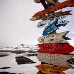 In this Jan. 20, 2015 photo, wooden arrows show the distances to various cities near Chile's Escudero station on King George Island, Antarctica. Thousands of scientists come to Antarctica for research. There are also non-scientists, chefs, divers, mechanics, janitors and the priest of the world's southernmost Eastern Orthodox Church on top of a rocky hill at the Russian Bellinghausen station. (AP Photo/Natacha Pisarenko)