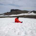 In this Jan. 24, 2015 photo, a worker from the Chile's Antarctic Institute sits on the snow on Robert Island, part of the South Shetland Islands archipelago in Antarctica. NASA uses the remoteness of Antarctic to study what people would have to go through if they visited Mars. The dry air also makes it perfect for astronomers to peer deep into space and into the past. (AP Photo/Natacha Pisarenko)
