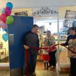 By IAN FOLEY Mayor Pat Porter and a young girl cut a ribbon held by Steve and Bobbi England on Monday, March 2 at Gotta Have Desserts in Kenai.