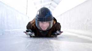 This undated photo provided by the Olympic Regional Development Authority shows  a person taking a skeleton ride at Mt. Van Hoevenberg in Lake Placid, N.Y.  For $75, visitors on winter Saturdays can take a sled ride belly down, head first on a sled the size of a throw rug. While racers take running jumps onto their sleds and can exceed 80 mph, visitors are pushed off about halfway down the run and can hit 30 to 40 mph.  (AP Photo/Olympic Regional Development Authority)
