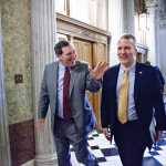 Sen. Joe Donnelly, D-Ind., left, and Sen. Dan Sullivan, R-Alaska, head to the chamber for a procedural vote on a funding bill for the Department of Homeland Security that has produced partisan gridlock in the first several weeks of the new Congress, at the Capitol in Washington, Monday, March 2, 2015. House Republicans want to use the measure to roll back President Obama's executive actions on immigration. Democrats have vowed to block any attempt to compromise on immigration and insist the Congress should approve a "clean" bill funding DHS. (AP Photo/J. Scott Applewhite)