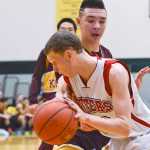 Photo by Rashah McChesney/Peninsula Clarion  Seldovia's Aidan Philpot works his way around Kotlik's Juwan Akaran during their game at the 2015 March Madness Small Schools championships on Saturday March 14, 2015 in Anchorage, Alaska.