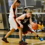 Photo by Rashah McChesney/Peninsula Clarion  Nikolaevsk's Neil Gordeev darts around Noorvik's Quinn Williamson during their game for the 2015 March Madness Small Schools Championship on Saturday March 14, 2015 in Anchorage, Alaska. Nikolavesk won 50-33.