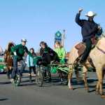 Ben Boettger/Peninsula Clarion Unicyclists and equestrians from Diamond M Ranch ride in the Soldotna St. Patrick's Day parade at the Kenai Spur Highway on Tuesday, March 17