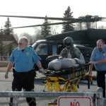 Ben Boettger/Peninsula Clarion Central Peninsula security officer Tom Randolph (left), a helicopter crew member, and security officer Richard Dominick transport an inflatable "patient" during a disaster preparedness exercise at Central Peninsula Hospital on Friday, March 20.