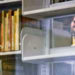 Photo by Rashah McChesney/Peninsula Clarion  Erik Hendrickson, of Nikiski, settles on a book about tiny houses on Wednesday April 8, 2015 at the Kenai Community Library in Kenai, Alaska.