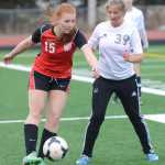 Photo by Kelly Sullivan/ Peninsula Clarion Kenai High School's Darby Milburn passes the ball off to a teammate before Soldotna High School's Bailey Rosen can intercept the pass Friday, April 17, 2015, at Kenai Central High School in Kenai, Alaska.