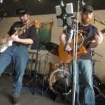 Ben Boettger/Peninsula Clarion Guitarist Lee Gatenby of Troubador North checks his effects rig while bassist Rusty Singleton warms up before a show on Sunday, April 25 at Coffee Roasters in Kenai.