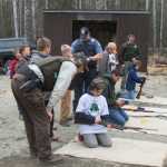 Officers Shay Hurd (Kenai National Wildlife Refuge), Daniel Carnow (NOAA), and Jacques Kosto (Alaska State Parks) help kids learn to shoot with air rifles. (Photo courtesy Kenai National Wildlife Refuge)