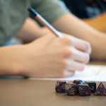 Photo by Rashah McChesney/Peninsula Clarion A pile of multi-sided dice lays on the table next to a character who plays Dungeons & Dragons with a group at the Soldotna library. The group is hosting its first community-wide all-day Dungeons & Dragons game on Saturday in the community room at the library.