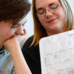 Photo by Rashah McChesney/Peninsula Clarion   (left) Morgan Stoddard laughs as Hans Hesse shows him a character sheet during their Dungeons & Dragons game on April 22, 2015 at the Soldotna Public Library. The group meets regularly at the library and will host a D&D marathon on Saturday for anyone in the community interested in playing the game.
