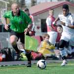 Ben Boettger/Peninsula Clarion Kenai 7 chases the ball as the referee chases him at a match against Soldotna on Saturday at Kenai Central High School.