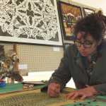 Ben Boettger/Peninsula Clarion Desiree Hagen of Homer cuts a pattern based on an Appalachian rag rug on Saturday at the Emerging Artists Festival at Soldotna Creek Park in Soldotna.