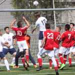 Homer senior Drew Brown (17) gets his head on a Homer corner kick above Kenai freshman Braydon Goodman (10) in the second half of Thursday's boys state quarterfinal match at Bartlett High School in Anchorage, while Homer senior Filip Reutov (5), senior Ben Knisely (13) and senior goalkeeper Eric Hill (partially hidden) look on. The Kardinals won 1-0, their first ever state match victory.