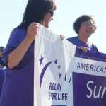 Photo by Kelly Sullivan/ Peninsula Clarion Linda Ruffridge, Romi Haseo and Janice Sadler hold the banner during the 2015 Relay For Life survivor's lap Friday, May 29, 2015, at the Soldotna Regional Sports Complex in Soldotna, Alaska.