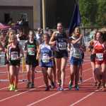 Kenai Central senior Allie Ostrander (488) jogs in front of the crowd with the field of runners after winning the 4A girls 3,200-meter race at the Alaska state track and field meet at Dimond Alumni Field in Anchorage.