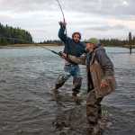 Photo by Rashah McChesney/Peninsula Clarion  Mike Matheny, of Kasilof, tries to see his fish as Matt Buta, of Soldotna, runs around him to keep a hold of his own as the two fished the Kasilof River on Tuesday June 2, 2015.