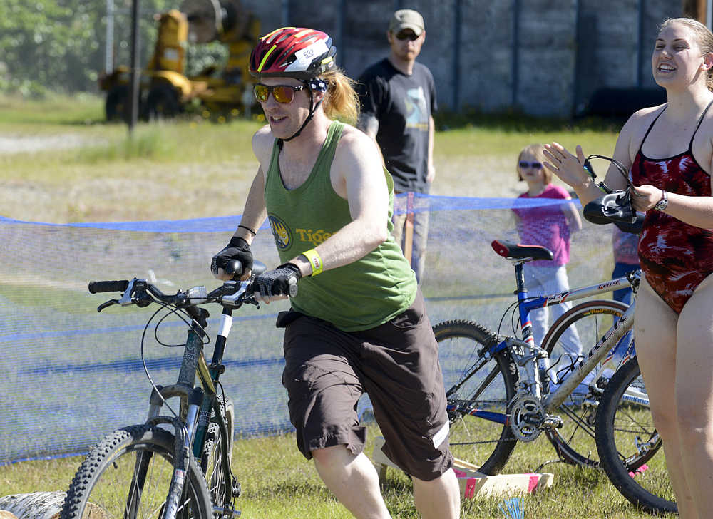 Photo by Rashah McChesney/Peninsula Clarion Ryan Peterson takes off with his bike as racing partner Chelsea Passmore cheers him on during the Tri the Kenai triathlon on June 14, 2015 in Soldotna, Alaska.