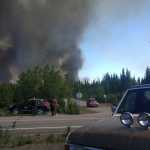 Photo by Kelly Sullivan/ Peninsula Clarion  Derick Williams and Brian Gibson climbed onto the top of Williams' truck to get a better view of the fire the Card Street Fire that had forced them to evacuate their homes Monday, June 15, 2015, on Feuding Lane in Sterling, Alaska.
