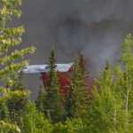 Derick Williams of Sterling stands on a vehicle shortly after being evacuated from his home on Alamo Avenue after a wildfire started in the area Monday. (Photo by Kelly Sulliva/Peninsula Clarion)