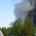 Photo by Kelly Sullivan/ Peninsula Clarion  Derick Williams and Brian Gibson climbed onto the top of Williams' truck to get a better view of the fire the Card Street Fire that had forced them to evacuate their homes Monday, June 15, 2015, on Feuding Lane in Sterling, Alaska.