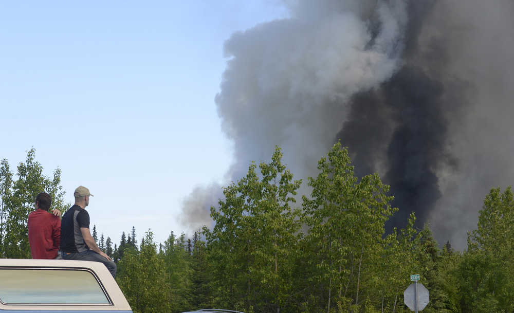 Photo by Kelly Sullivan/ Peninsula Clarion  Derick Williams and Brian Gibson climbed onto the top of Williams' truck to get a better view of the fire the Card Street Fire that had forced them to evacuate their homes Monday, June 15, 2015, on Feuding Lane in Sterling, Alaska.