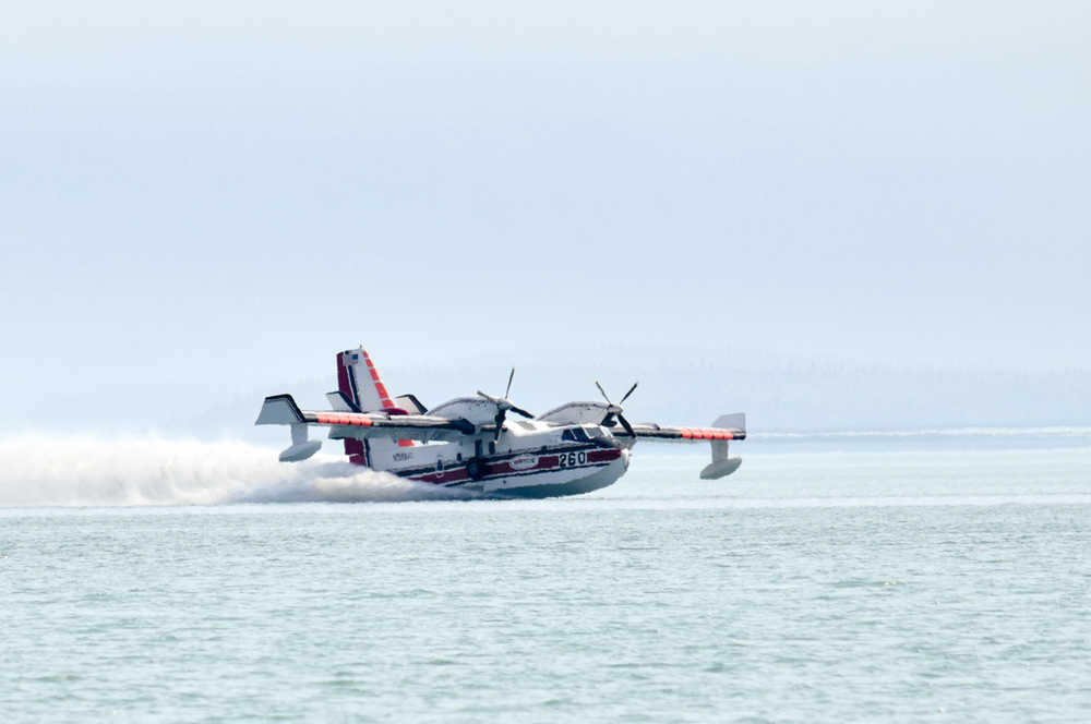 Photo by Rashah McChesney/Peninsula Clarion  A water bomber scoops water from Skilak Lake to fight the Card Street wildfire on Tuesday June 16, 2015 near Sterling, Alaska. The fire began moving northeast and authorities evacuated campgrounds on Skilak Loop Road on the Kenai National Wildlife Refuge. A portion of Skilak Loop Road has also been closed to the Lower Skilak Lake Campground, thought the boat launch remained open. The Kenai Peninsula Borough's Office of Emergency Management reports that 10 structures have been damaged in the fire, including three homes. It is estimated to have consumed about 1800 acres.