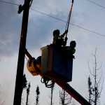 Photo by Rashah McChesney/Peninsula Clarion  HEA linemen work on the power lines in the early morning hours as spot fires burn close by near the Kenai Keys subdivision where the Card Street fire has burned thousands of acres and several structures.