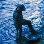 Photo by Rashah McChesney/Peninsula Clarion Pedro Ortiz, of Anchorage, washes two fresh caught red salmon in the Russian River on Thursday June 11, 2015 near Cooper Landing, Alaska.