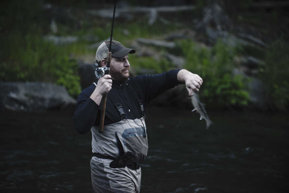 Photo by Rashah McChesney/Peninsula Clarion An angler works to pop a smaller fish off of his hook during the Russian River sockeye salmon opener on Thursday June 11, 2015 near Cooper Landing, Alaska.